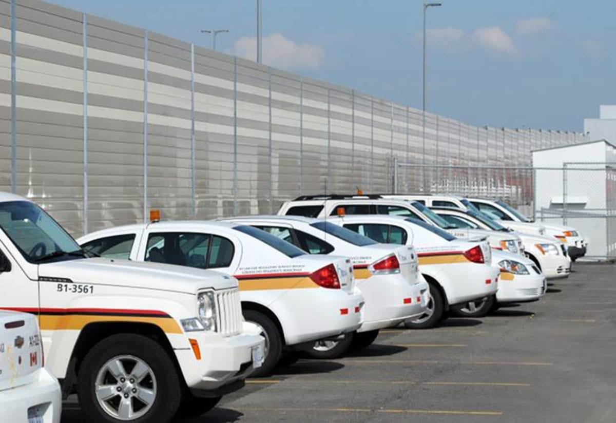 Sound walls enclose a municipal parking lot.