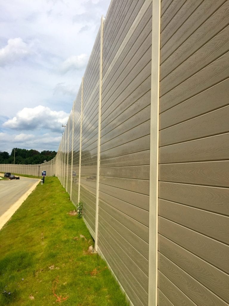 Close angle view of sound barrier wall with embossed wood grain texture