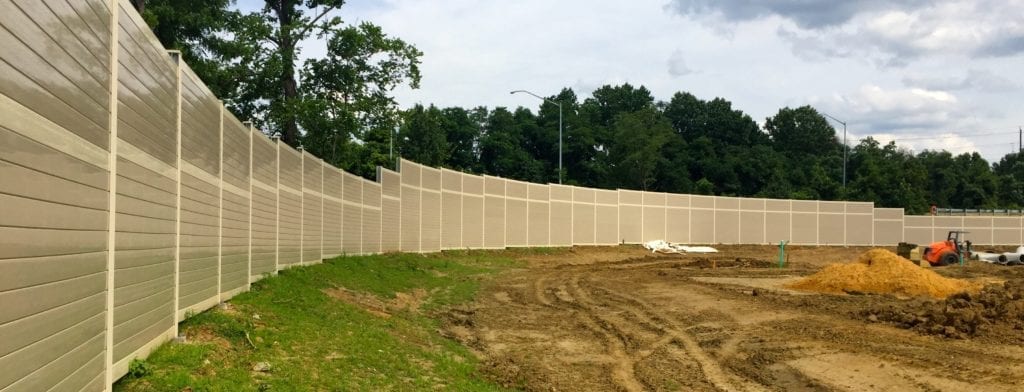 Wide view of gracefully curving noise barrier wall for residential development