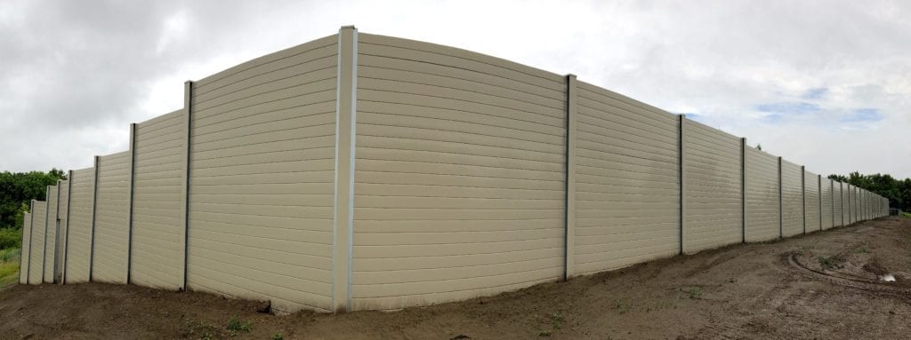 Full width exterior view of 140 m railway sound barrier wall around condo development