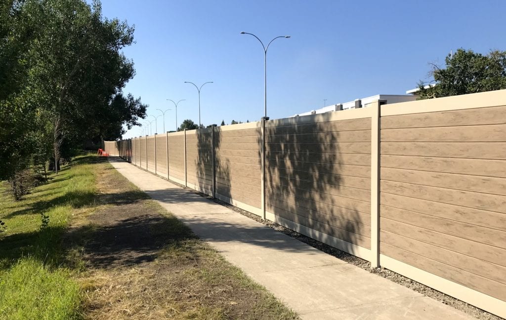Closer sidewalk view of Calgary highway sound barrier wall