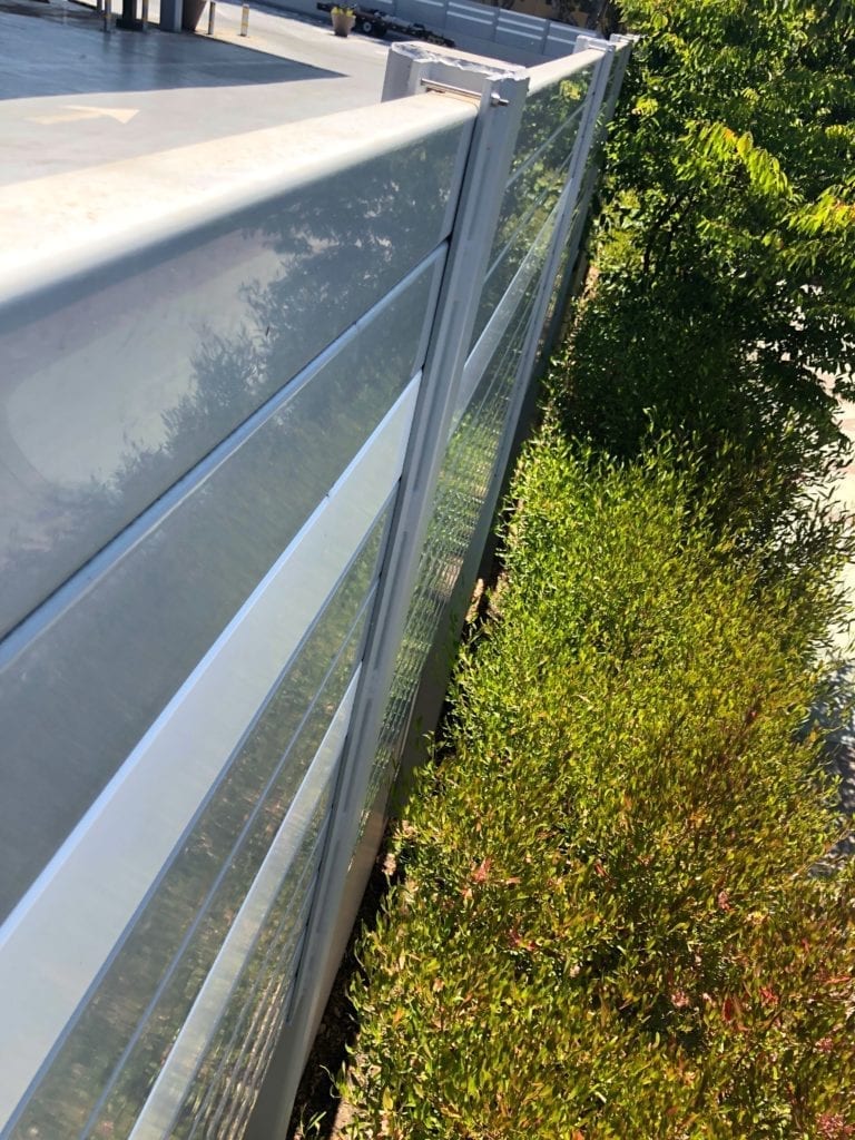 Exterior close-up of undisturbed landscaping next to sound barrier wall