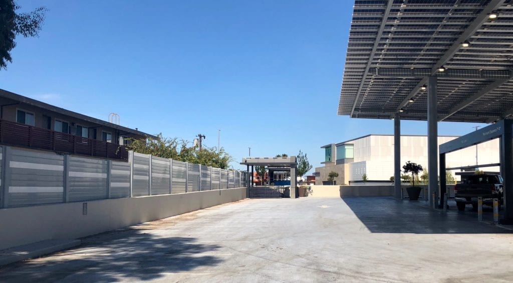 Wide view of sound barrier wall mounted to side of parking structure