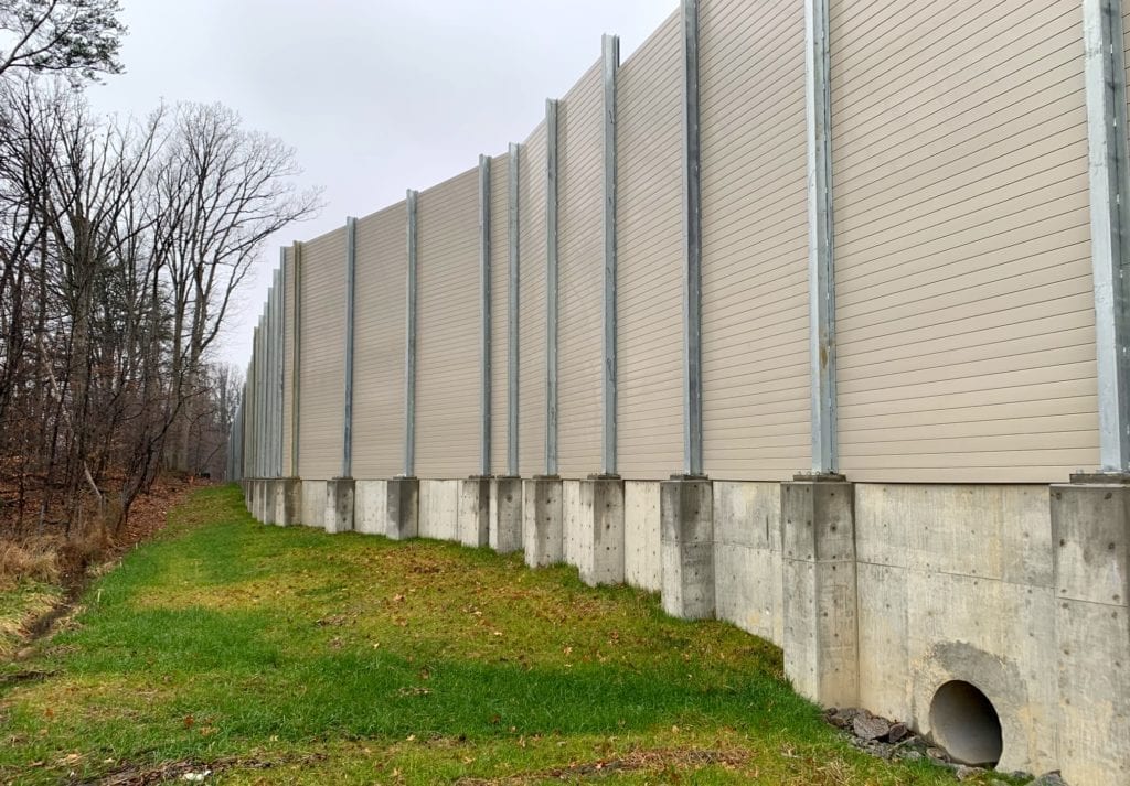 Sound barrier wall mounted to CIP retaining wall