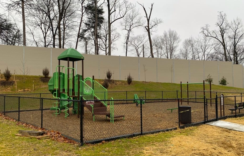 Playground in front of residential noise barrier wall