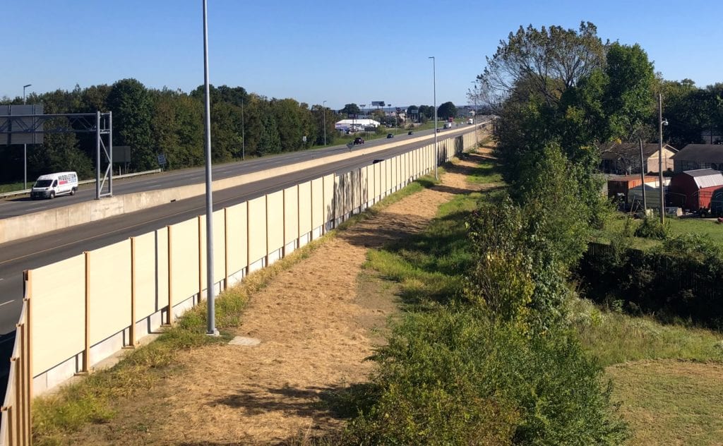 Overpass view of back of highway noise barrier wall