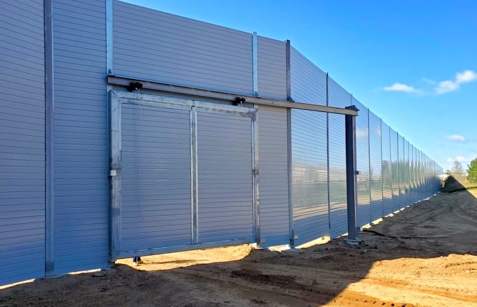 Wide exterior view of sound barrier wall with large sliding door