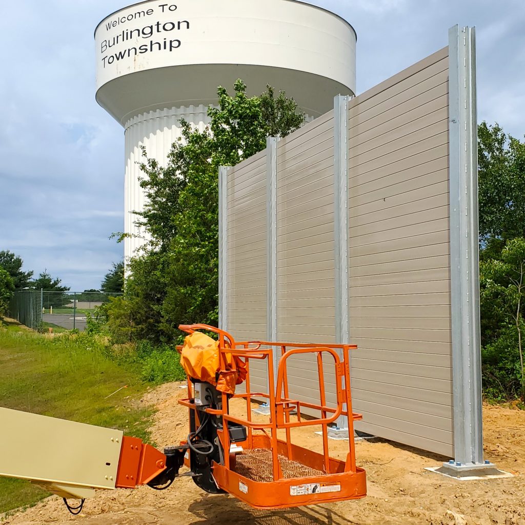 Section of distribution center noise barrier wall by water tower