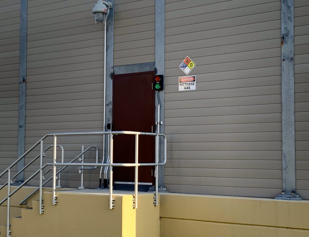 View of sound barrier wall equipment enclosure with door