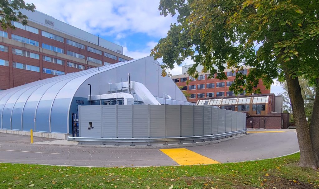 Wide view of curved equipment enclosure with attached guardrail