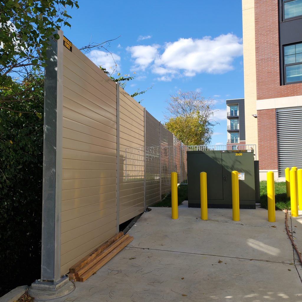 Noise barrier wall snugs closely to electrical structure