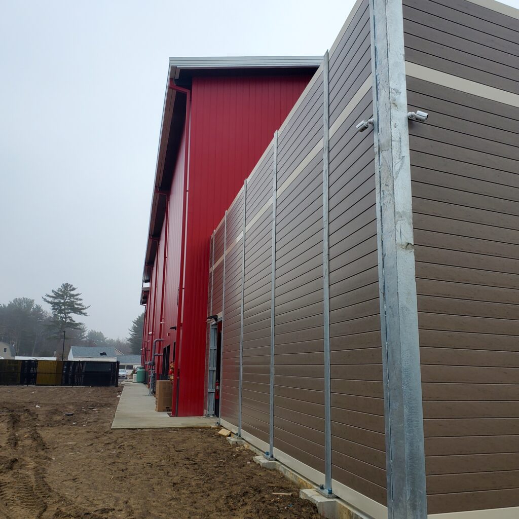 Long side of noise barrier wall equipment enclosure