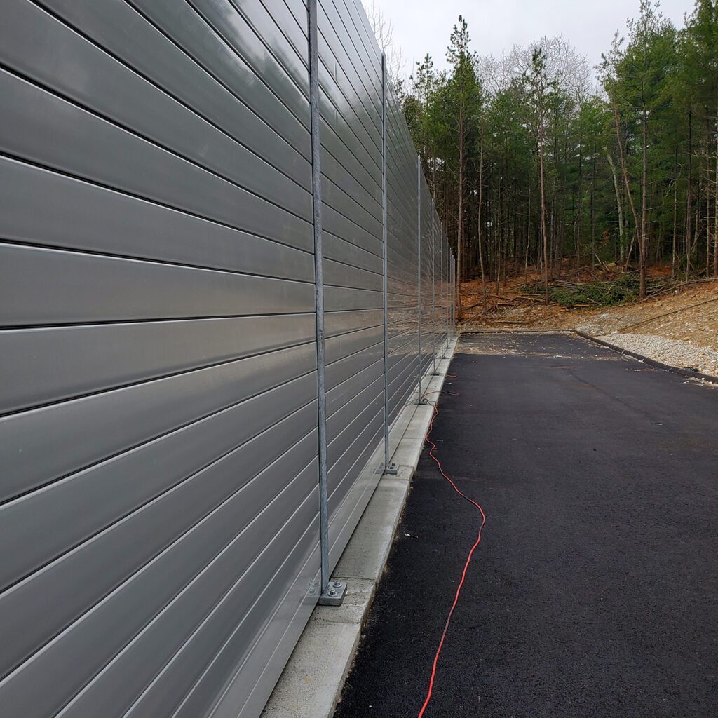 Long side of noise barrier wall equipment enclosure