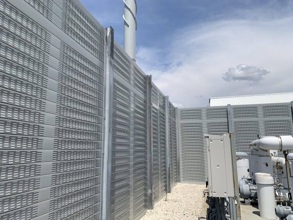 Long side of noise barrier wall equipment enclosure