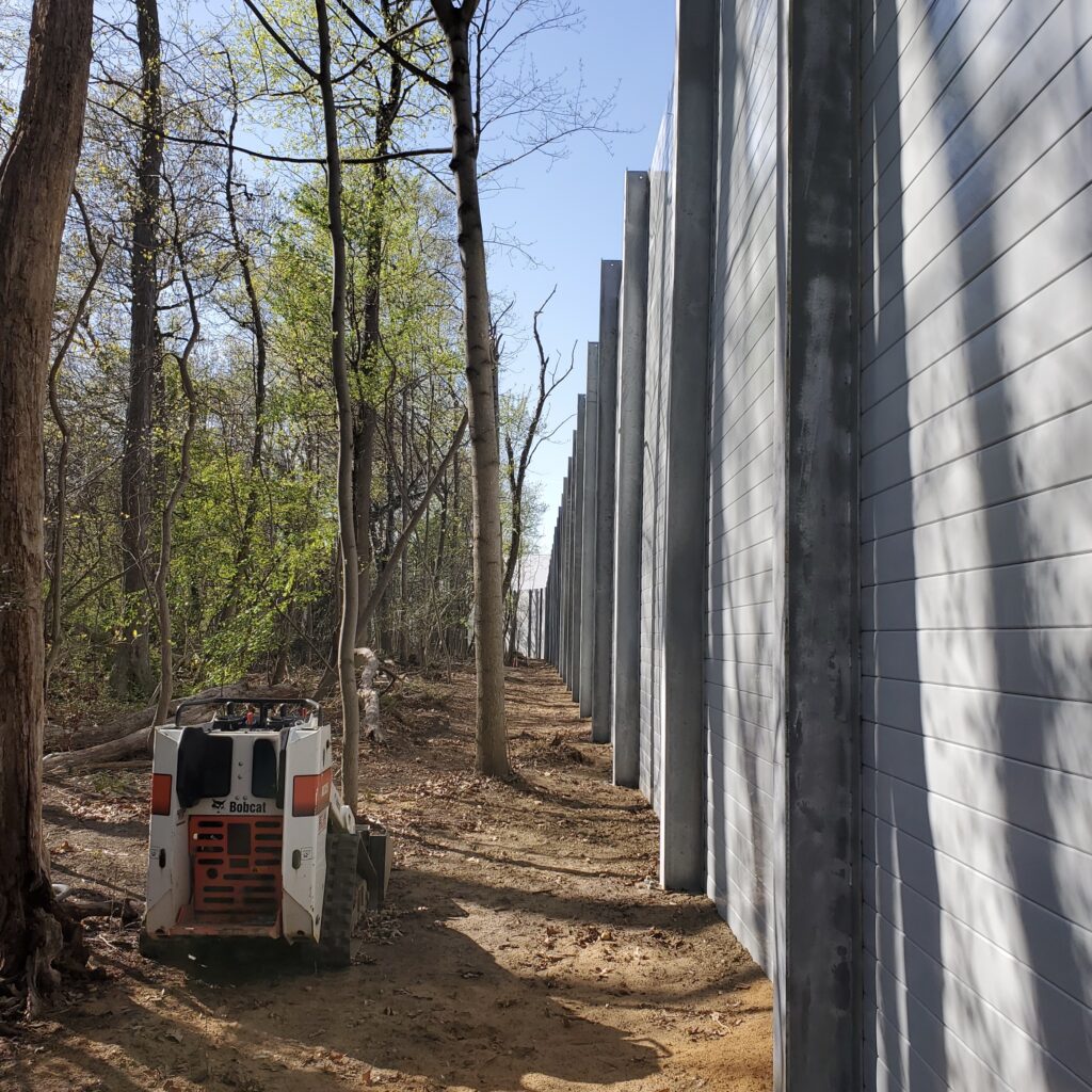 Outside view of sound barrier wall next to trees
