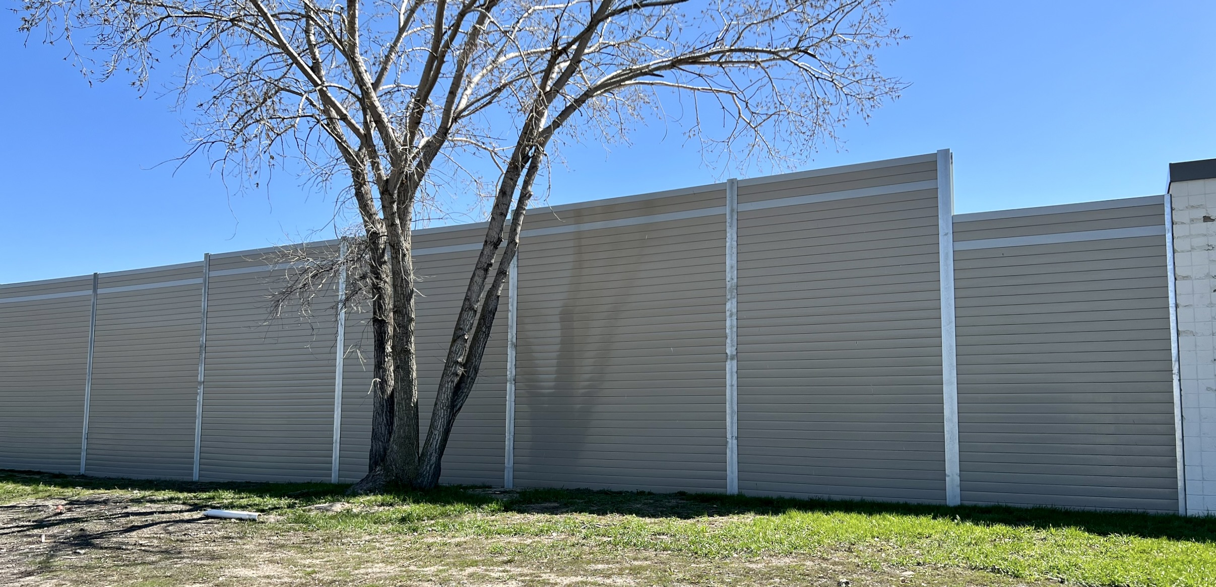Wide view of sound barrier wall adjoining FedEx logistics center
