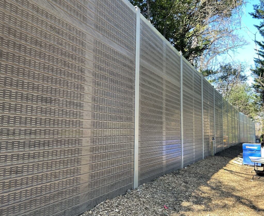Detail views of noise barrier wall running through wooded area