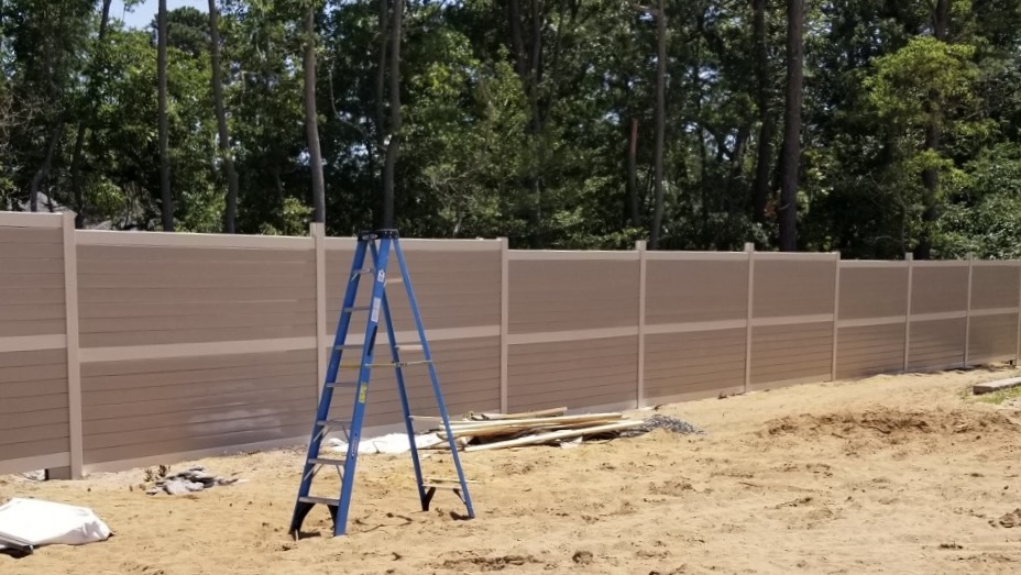 Drive-thru lane noise barrier wall for a Wawa store